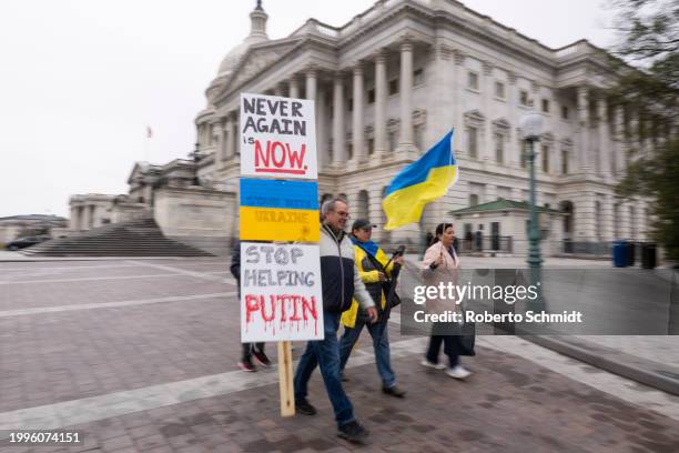 Ukraine sympathizers carry placards and fly a Ukrainian flag outside the U.S. Capitol building as the Senate works through the weekend on a $95.3...