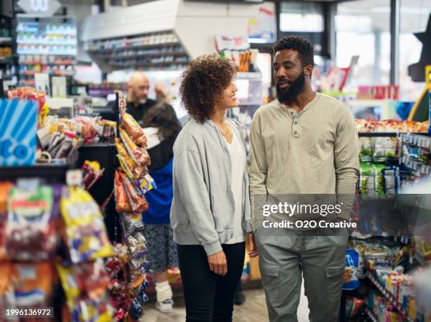 pareja joven de compras en una tienda de conveniencia - tienda del vecindario fotografías e imágenes de stock