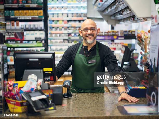 small business owner at work in his small convenience store - convenience store counter stock-fotos und bilder