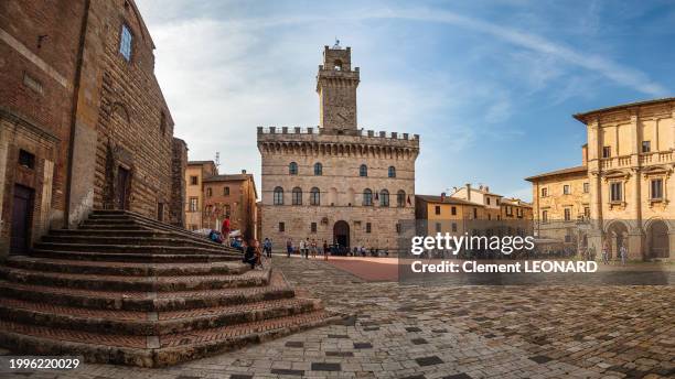 panoramic view of the crowded piazza grande, the main square and landmark of the old town of montepulciano, showing the santa maria assunta cathedral and the town hall, siena province - tuscany - italy. - montepulciano stock pictures, royalty-free photos & images