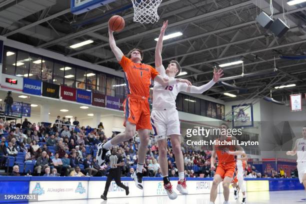 Ian Motta of the Bucknell Bison drives to the basket over Matt Rogers of the American University Eagles during a college basketball game at Bender...