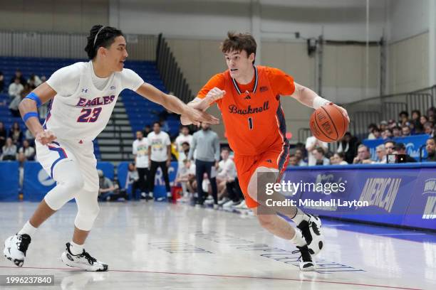 Ian Motta of the Bucknell Bison dribbles by Greg Jones of the American University Eagles during a college basketball game at Bender Arena on February...