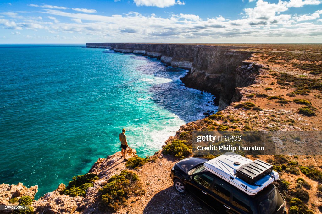 Aerial view of car parked with camper and young man overlooking the Great Australian Bight
