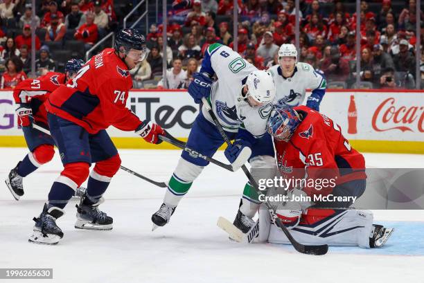 Darcy Kuemper of the Washington Capitals makes a save as J.T. Miller of the Vancouver Canucks looks for a rebound during a game at Capital One Arena...