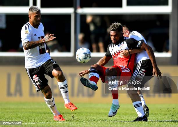 Miguel Borja of River Plate competes for the ball with Nicolas Dematei and Milton Celiz of Deportivo Riestra during a Copa de la Liga 2024 group A...