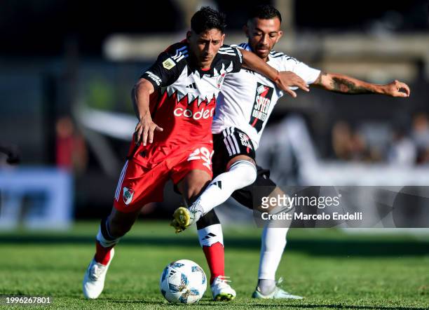 Rodrigo Aliendro of River Plate competes for the ball with Nicolas Benegas of Deportivo Riestra during a Copa de la Liga 2024 group A match between...