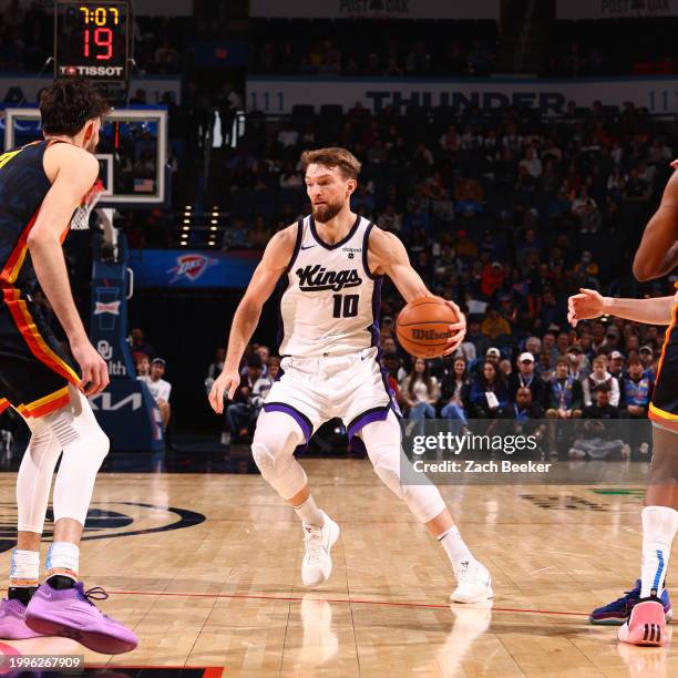 Domantas Sabonis of the Sacramento Kings dribbles the ball during the game against the Oklahoma City Thunder on February 11, 2024 at Paycom Arena in...