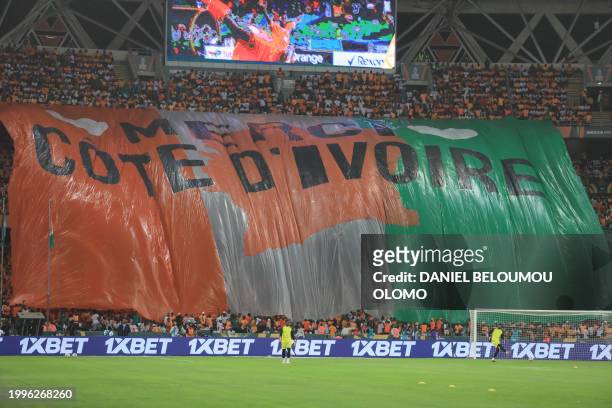 Ivory Coast supporters hold a giant banner ahead of the Africa Cup of Nations 2024 final football match between Ivory Coast and Nigeria at Alassane...