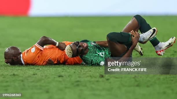 Nigeria's forward Victor Osimhen and Ivory Coast's midfielder Seko Fofana react after picking up an injury during the Africa Cup of Nations 2024...