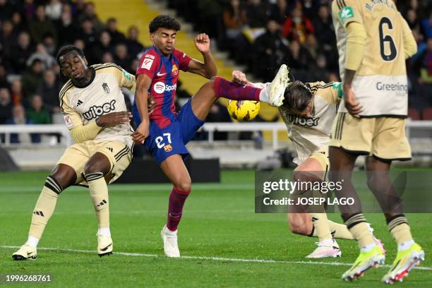 Barcelona's Spanish forward Lamine Yamal fights for the ball with Granada's Cameroonian midfielder Martin Hongla and Granada's Spanish defender...