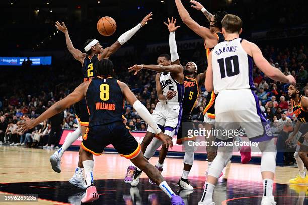 De'Aaron Fox of the Sacramento Kings passes the ball while surrounded by members of the Oklahoma City Thunder during the second half at Paycom Center...