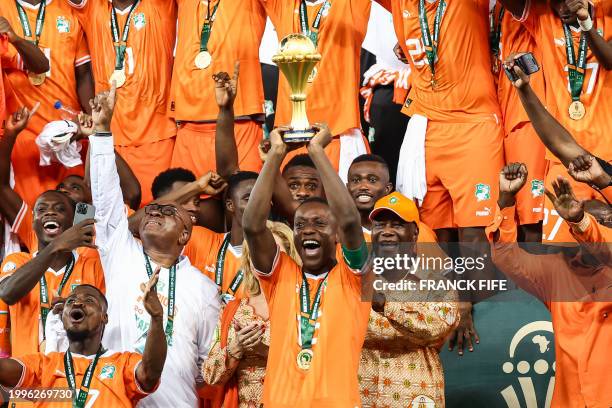 Ivory Coast's forward Max-Alain Gradel lifts the Africa Cup of Nations trophy on the podium after Ivory Coast won the Africa Cup of Nations 2024...