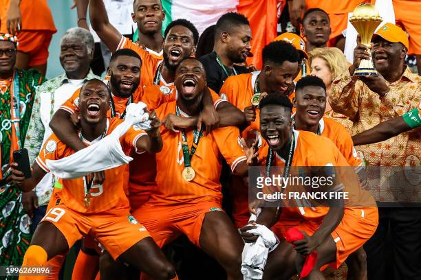 President of Ivory Coast Alassane Ouattara lifts the Africa Cup of Nations trophy on the podium after Ivory Coast won the Africa Cup of Nations 2024...