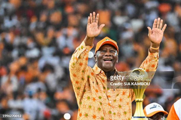 President of Ivory Coast Alassane Ouattara waves to the fans nex to the Africa Cup of Nations trophy after Ivory Coast won the Africa Cup of Nations...