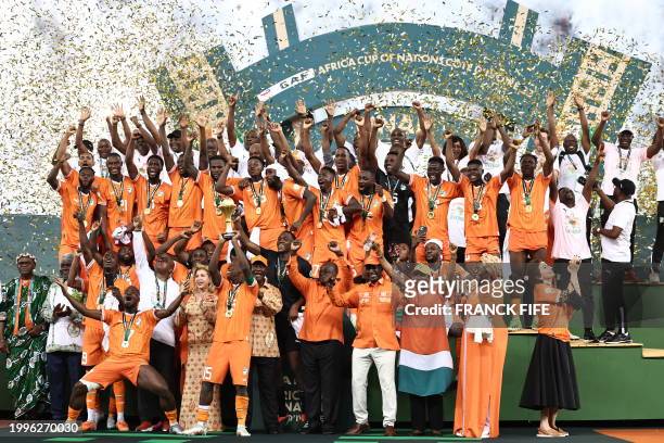 Ivory Coast's forward Max-Alain Gradel lifts the Africa Cup of Nations trophy on the podium after Ivory Coast won the Africa Cup of Nations 2024...