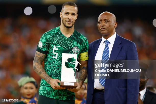 Nigeria's defender William Troost-Ekong holds the Golden Ball award while standing next to President of the Confederation of African Football Patrice...