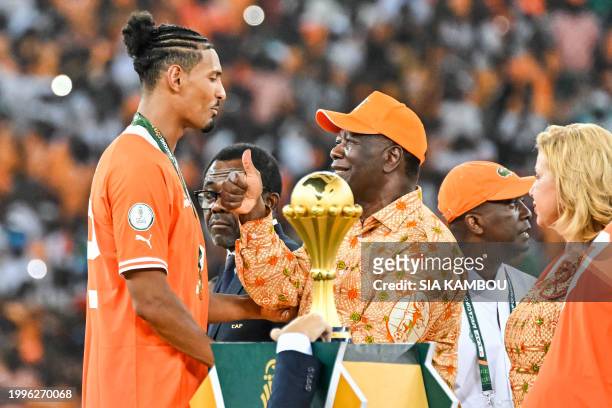 President of Ivory Coast Alassane Ouattara congratulates Ivory Coast's forward Sebastien Haller after winning at the end of the Africa Cup of Nations...