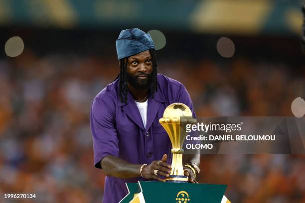 Former Togolese football star Emmanuel Adebayor places the Africa Cup of Nations trophy to the podium after Ivory Coast won the Africa Cup of Nations...