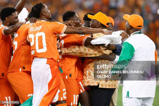 Ivory Coast players hug President of Ivory Coast Alassane Ouattara after they won the Africa Cup of Nations 2024 final football match between Ivory...