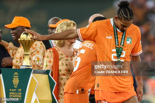 Ivory Coast's forward Sebastien Haller touches the Africa Cup of Nations trophy after Ivory Coast won the Africa Cup of Nations 2024 final football...