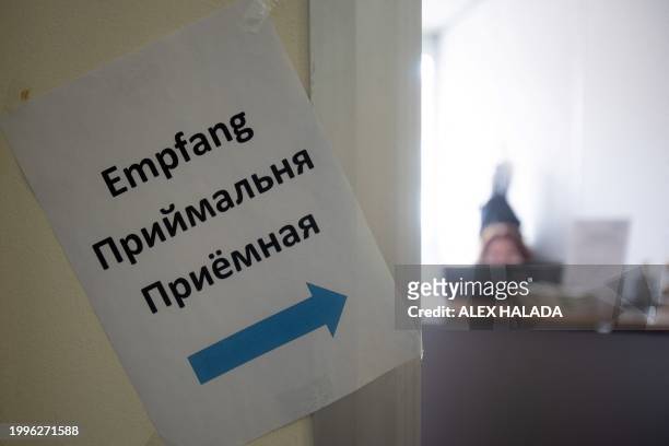 Photo taken in Vienna, Austria on February 8, 2024 shows a sign in German and Ukrainian language pointing the way to the reception of the Ukrainian...