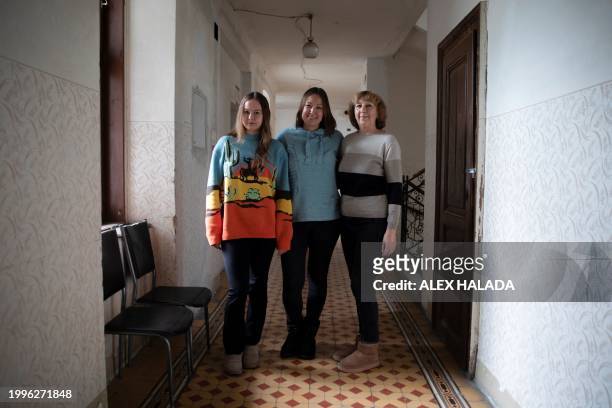 Mother Maryna Troshchenko from southern Ukraine with her daughter Katya Troshchenko and grandmother Iryna Simonova pose for photos in the building...