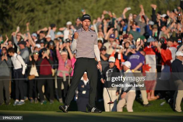 Nick Taylor of Canada fist pumps after making a putt on the 18th green to force a playoff hole during the final round of WM Phoenix Open at TPC...