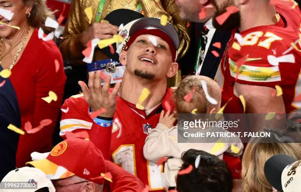 Kansas City Chiefs' quarterback Patrick Mahomes with his son Patrick Bronze watches confettis as they celebrate winning Super Bowl LVIII against the...