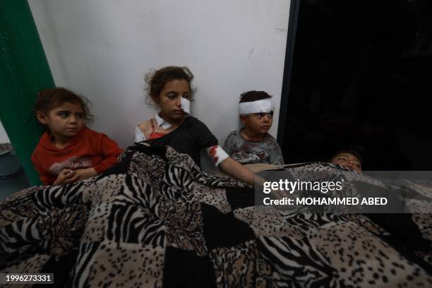 Wounded Palestinian girl Somay al-Najar comforts her siblings following Israeli bombardments over Rafah in the southern Gaza Strip on February 12,...