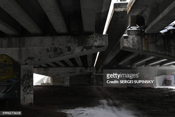 This photograph taken on February 10, 2024 shows a view under a destroyed bridge in Irpin town, outside Kyiv, amid the Russian invasion of Ukraine.