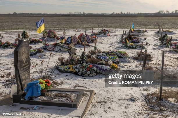 This photograph taken on January 23, 2024 shows graves most of which are of the victims killed during the Russian strike last year on a shop and cafe...