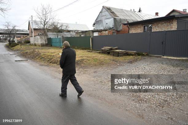 Wan walks on a road in the village of Solonka near the western Ukrainian city of Lviv, on February 10 where a Russian missile struck on November 16,...