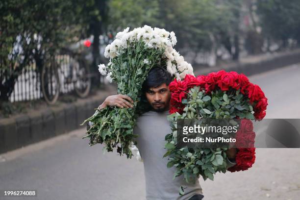 Vendor is carrying flowers at a wholesale flower market ahead of Valentine's Day in Dhaka, Bangladesh, on February 12, 2024.