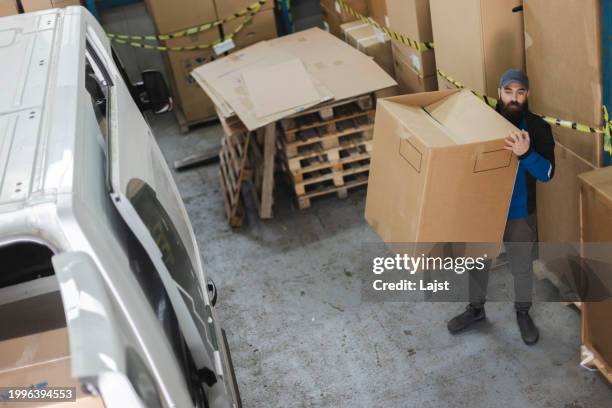 a warehouse worker works in a warehouse - achterbak-van-auto stockfoto's en -beelden