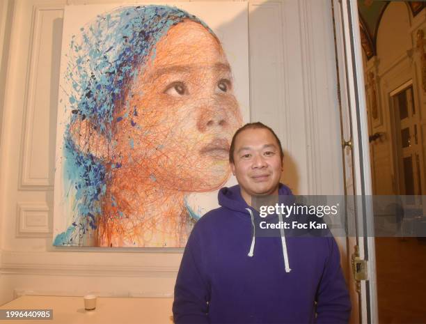 Painter Hom Nguyen poses with his work during the Hom Nguyen’s preview of the "Peace" exhibition at Mairie du 13eme on February 08, 2024 in Paris,...