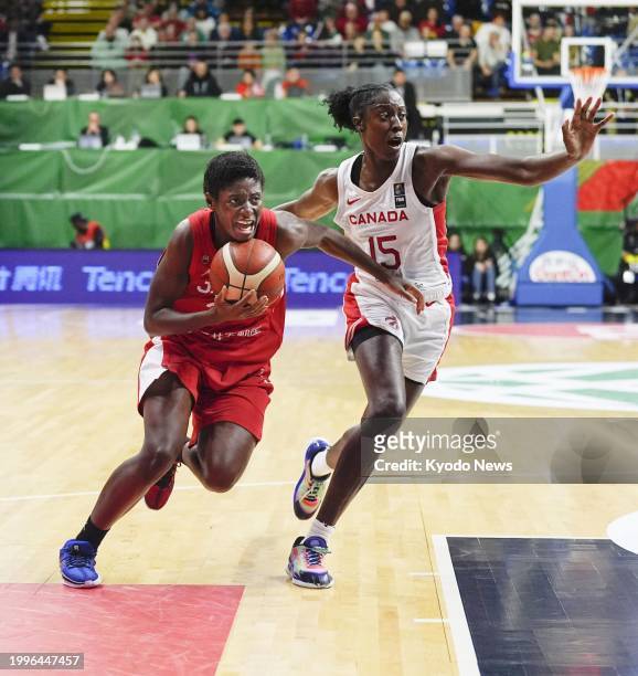 Japan's Evelyn Mawuli goes on the attack as Canada's Laeticia Amihere plays defense in the first quarter of an Olympic women's basketball qualifier...
