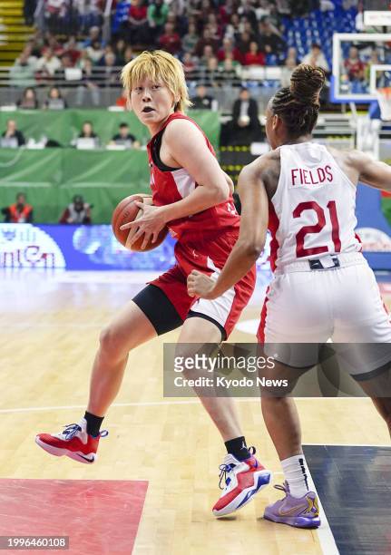 Japan's Maki Takada is in action while Canada's Nirra Fields plays defense in the first quarter of an Olympic women's basketball qualifier on Feb. 11...