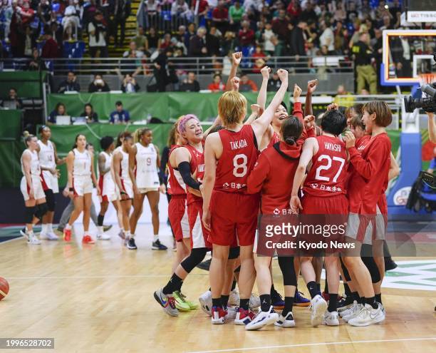 Members of Japan women's basketball team celebrate after qualifying for the 2024 Paris Olympics by defeating Canada in a four-team qualifying...