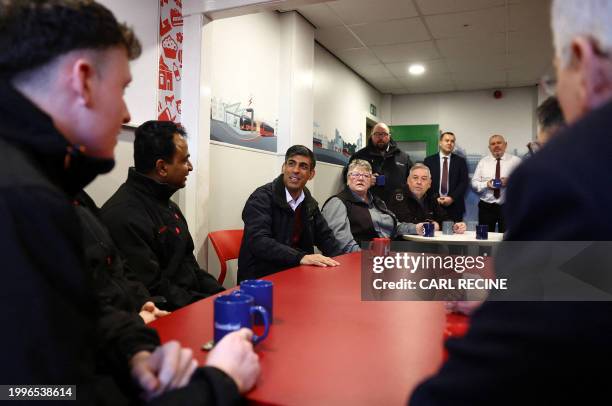 Britain's Prime Minister Rishi Sunak talks with bus drivers during a visit to a bus depot in Harrogate, northern England on February 12, 2024.