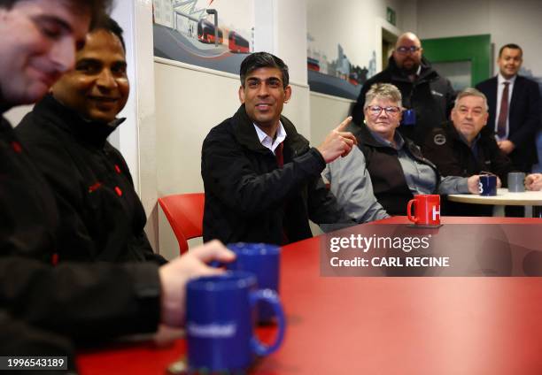 Britain's Prime Minister Rishi Sunak talks with bus drivers during a visit to a bus depot in Harrogate, northern England on February 12, 2024.