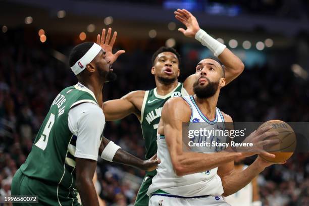 Rudy Gobert of the Minnesota Timberwolves is defended by Bobby Portis and Giannis Antetokounmpo of the Milwaukee Bucks during the first half of a...