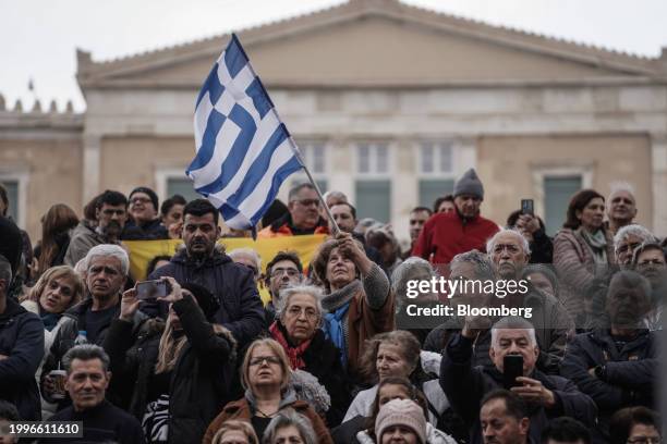 Protester waves a Greek flag outside the parliament building during a demonstration against the upcoming vote on the same-sex marriage bill, in...