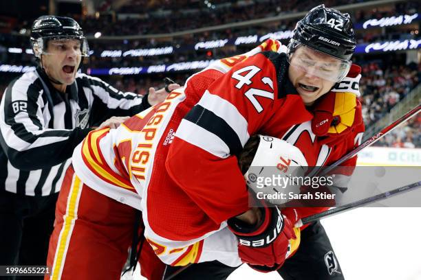 Linesman Ryan Galloway reacts as Curtis Lazar of the New Jersey Devils and Martin Pospisil of the Calgary Flames fight during the third period at...
