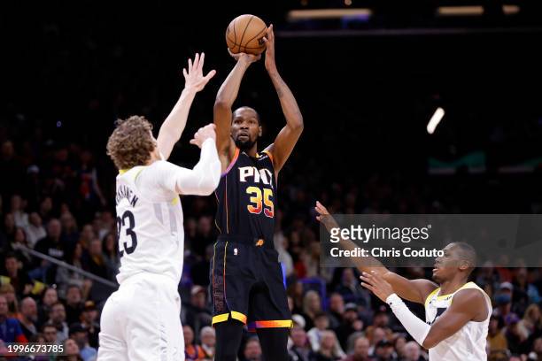Kevin Durant of the Phoenix Suns shoots over Lauri Markkanen of the Utah Jazz and Kris Dunn during the first half at Footprint Center on February 08,...