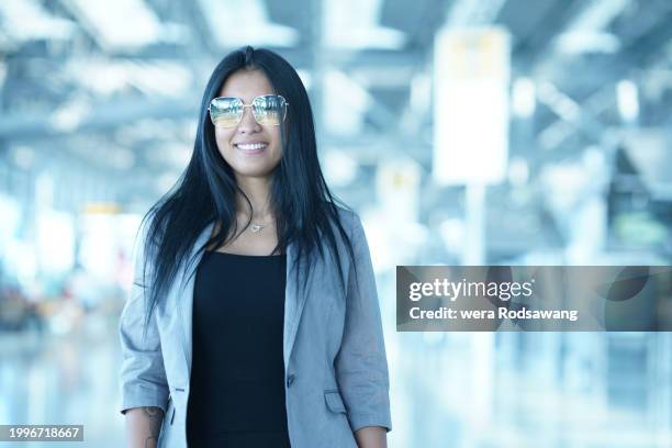 portrait of asian woman standing at arrive airport terminal - immigrants crossing sign stock pictures, royalty-free photos & images