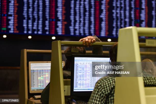 Stock brokers monitor share prices on computers during a trading session at the Pakistan Stock Exchange in Karachi on February 12, 2024. The...