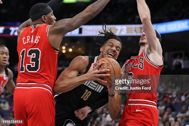 Tosan Evbuomwan of the Memphis Grizzlies drives to the basket between Torrey Craig of the Chicago Bulls and Alex Caruso of the Chicago Bulls during...