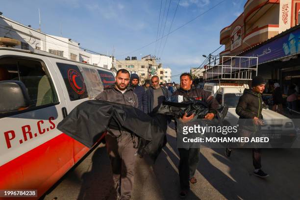 People carry bodies of loved ones killed during Israeli bombardment at Al-Najar hospital in Rafah, on the southern Gaza Strip on February 12 amid...