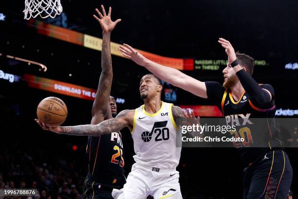 John Collins of the Utah Jazz attempts a layup against Jusuf Nurkic of the Phoenix Suns and Nassir Little during the second half at Footprint Center...