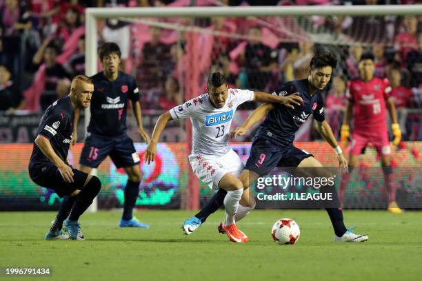 Diego Macedo of Consadole Sapporo controls the ball against Souza and Kenyu Sugimoto of Cerezo Osaka during the J.League J1 match between Cerezo...